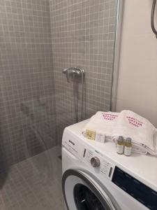 a washing machine in a bathroom with a shower at Apartman Sofija in Teslić