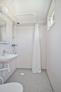 a white bathroom with a sink and a shower at Visby Gustavsvik in Visby +29 photos