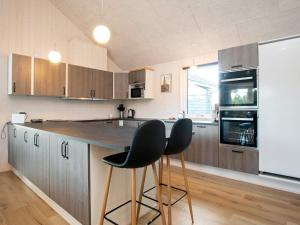 a kitchen with a counter and two bar stools at 5 star holiday home in Jerup in Jerup +48 photos
