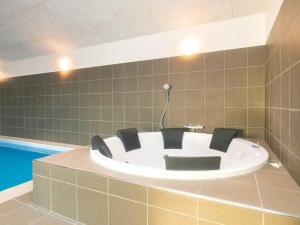 a bath tub with black chairs in a bathroom at 22 person holiday home in Jerup in Jerup +23 photos