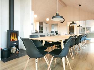 a dining room with a table and chairs and a fireplace at 5 star holiday home in Jerup in Jerup