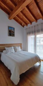 ein großes weißes Bett in einem Zimmer mit einem großen Fenster in der Unterkunft VV Casa Zalo in Cangas de Onís + 19 Fotos