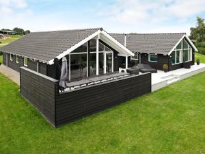 a black house with a deck and a roof at 5 star holiday home in Faaborg in Bøjden