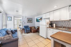 Parrot Bay 17 في آوشين سيتي: مطبخ وغرفة معيشة مع أريكة وثلاجة