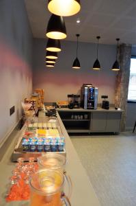 a cafeteria with a row of drinks on a counter at Hôtel Le Nautic in Arcachon