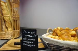 a basket of croissants and a sign next to a basket of bread at Hôtel Le Nautic in Arcachon