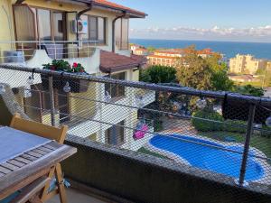 balcón con vistas al jardín y a la piscina en Sea View Apartment in Byala, en Byala