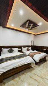 two beds in a room with a ceiling at S R Hotel in Varanasi