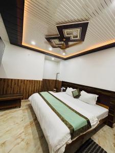 a bedroom with a large bed with a ceiling at S R Hotel in Varanasi +29 photos