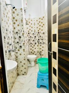 a bathroom with a toilet and a sink and a tub at S R Hotel in Varanasi