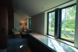 a room with two large windows and a room with a couch at Nature Base Hotel NUPPUKOTTE in Teshikaga +104 photos