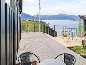 a deck with chairs and a table and a view of the water at 4 person holiday home in Øydegard-By Traum in Torvikbukt