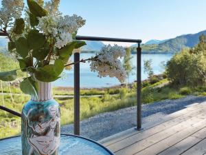 a glass table with a vase with flowers on it at 4 person holiday home in Øydegard-By Traum in Torvikbukt