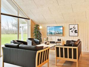 a living room with a couch and chairs and a table at 5 star holiday home in Kappeln in Kappeln +10 photos