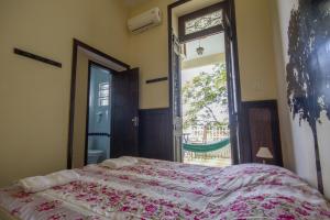 ein Schlafzimmer mit einem Bett und einem großen Fenster in der Unterkunft Rio Forest Hostel in Rio de Janeiro
