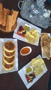 a table topped with plates of food with eggs and bread at Chambres au sein d'une villa in Rabat