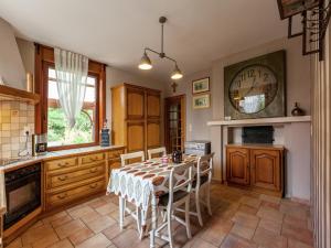 Una cocina con una mesa y un reloj en la pared. en Spacious Family Home, en Le Bizet