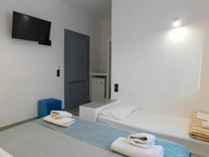 a bedroom with a bed with two towels on it at Vamos Ala Playa Perissa in Perissa