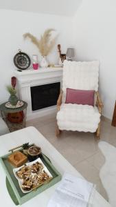 a living room with a white chair and a table at Home Delic Komarnica in Šavnik