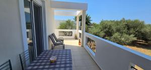 a balcony of a house with two chairs and a table at Olive Paradise Maison in Kos Town