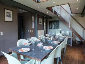 a dining room with a long table and white chairs at Les Terrasses Charming cottage in the heart of the Ardennes in Waimes