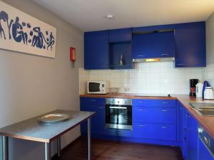 a kitchen with blue cabinets and a counter top at Les Terrasses Charming cottage in the heart of the Ardennes in Waimes