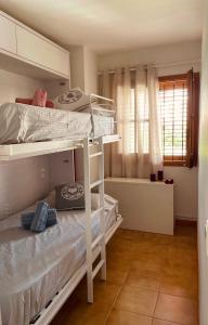 a bedroom with two bunk beds and a window at Casa en Sant Antoni de Calonge in Calonge