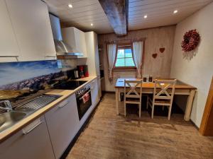 a kitchen with a table and a stove top oven at Scherntreinerhof in Westendorf