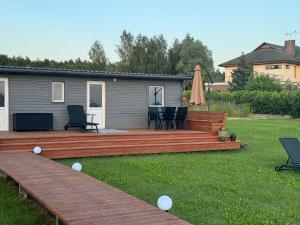 a deck with chairs and a table in a yard at Summer house Sunny coast in Lankstiņi