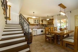 a kitchen and dining room with a table and a staircase at Villa Luca with pool and jacuzzi in Vrh