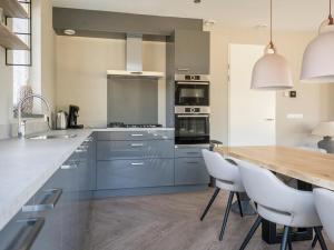 a kitchen with blue cabinets and a wooden counter top at Luxurious villa for 8 people in De Cocksdorp Texel in De Cocksdorp