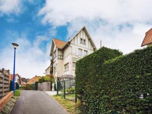 een wit huis met een heg ervoor bij Holiday Home in Koksijde near Beach in Koksijde