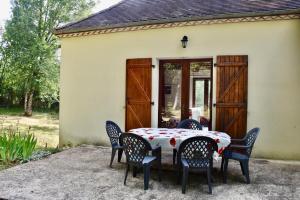 a table and chairs in front of a house at Maison de charme à la campagne in Dégagnac