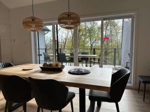 a dining room with a wooden table and chairs at New chalet with Spa and Swimming pool - Le Must in Brownsburg +18 photos