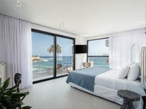 a bedroom with a bed and a view of the ocean at Theta Boutique Hotel in Chania