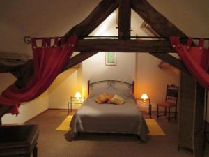 a bedroom with a large bed with red curtains at Holiday Home in Isenay near Lake and Forest in Isenay