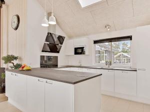 Una cocina con gabinetes blancos y una isla grande. en 16 person holiday home in Vejby, en Vejby