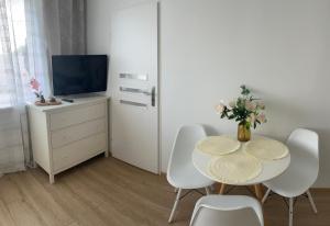 Un comedor con mesa y sillas y un televisor. en Mieszkanie blisko morza Gdańsk Stogi, en Gdansk