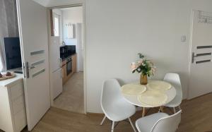 Un comedor con mesa y sillas y una cocina. en Mieszkanie blisko morza Gdańsk Stogi, en Gdansk