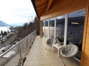 a porch with two chairs and a table on a balcony at Wohnung in Treffen nahe Gerlitzen Skipisten in Stöckelweingarten