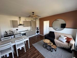 a living room with a couch and a table at Stella - 1km plage - centre ville in Stella-Plage