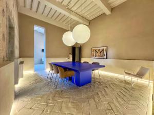 Un comedor con una mesa y sillas azules. en Residenza Neri-Serneri, en Foiano della Chiana