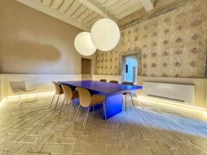 Un comedor con una mesa y sillas azules. en Residenza Neri-Serneri, en Foiano della Chiana
