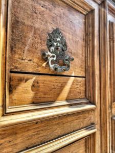 Una puerta de madera con un llamador de metal. en Residenza Neri-Serneri, en Foiano della Chiana