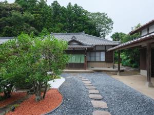 a house with a gravel driveway and trees in front at 円坐 enza in Katori