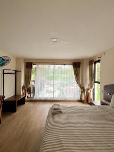 a large bedroom with a bed and a large window at wisma rotterdam in Madandan