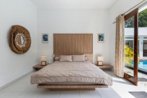 Un dormitorio con una cama y una ventana grande. en Soma Villa by Betterplace, en Jimbaran 77 fotos más