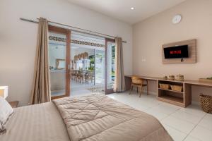 Un dormitorio con una cama y un escritorio con televisión. en Soma Villa by Betterplace, en Jimbaran
