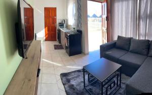 a living room with a couch and a table at MV self-catering Linden in Bloemfontein