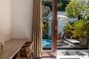 Un espejo en una sala de estar con una mesa y una piscina. en Soma Villa by Betterplace, en Jimbaran